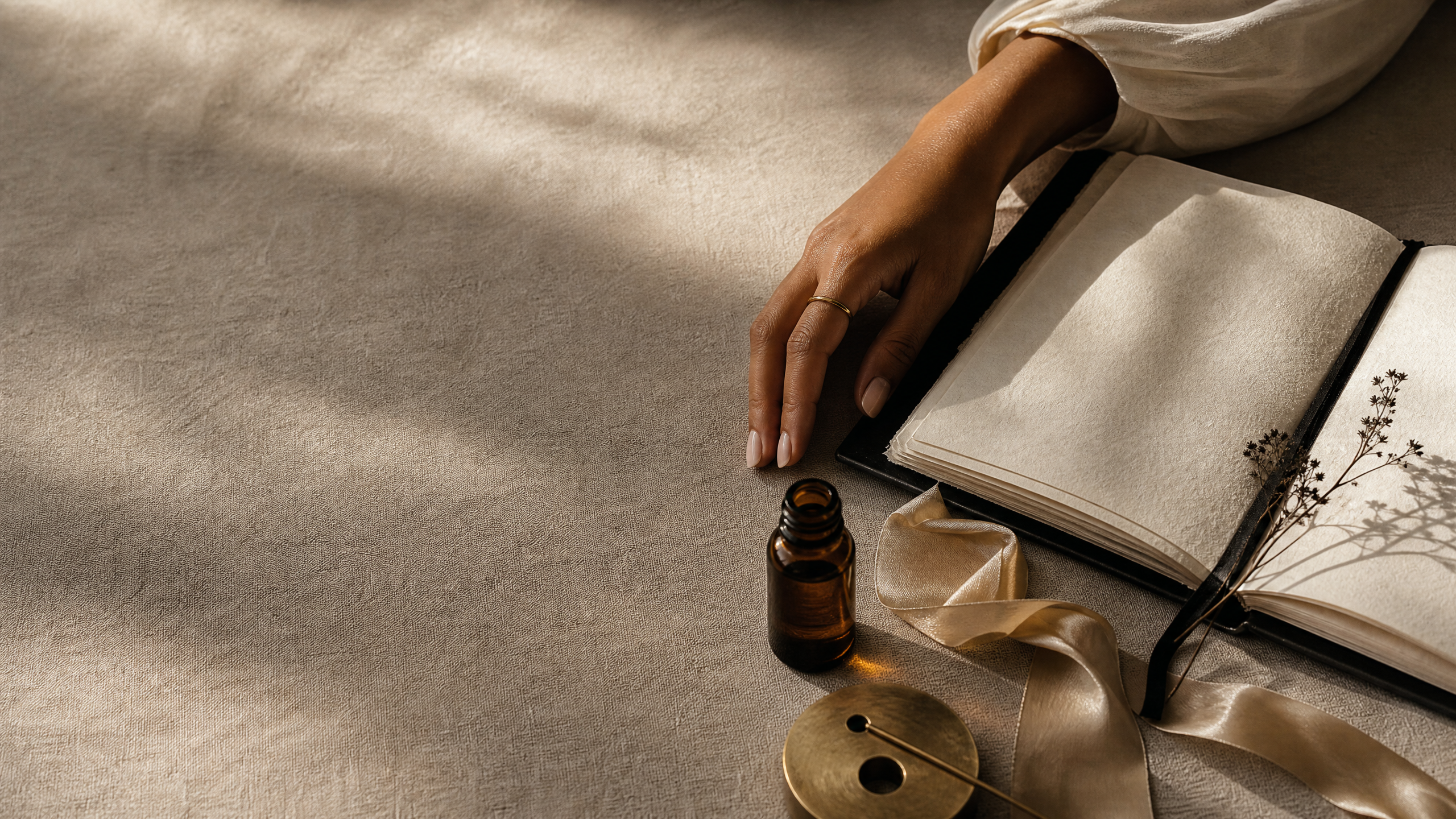 An open journal and quiet ritual objects on linen